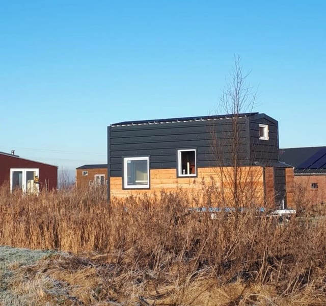 Afgebouwd tiny huis met houten gevel op een winterse dag